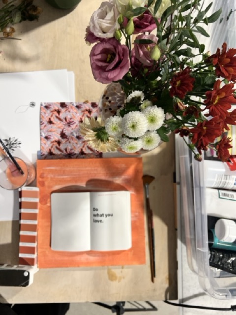 Blumen und Skizzenbuch auf dem Tisch